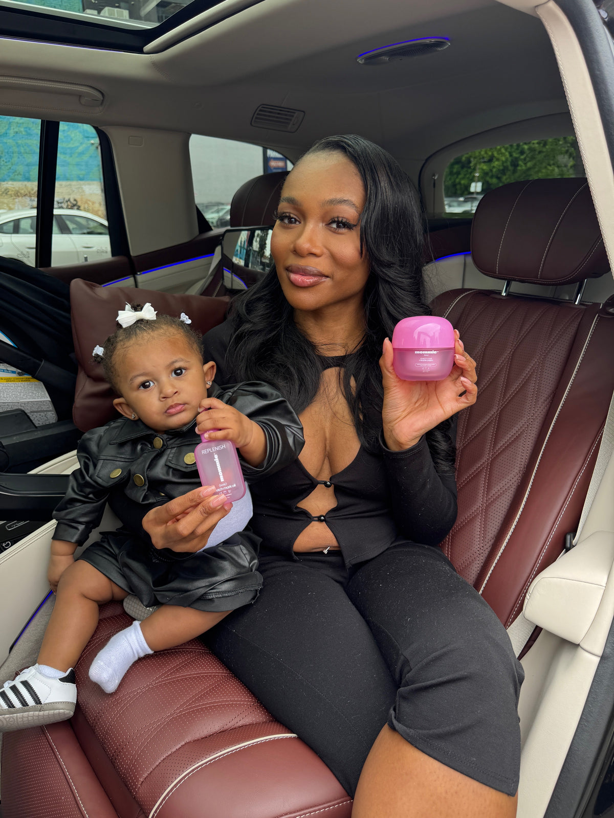 Woman holding Mommie Skin pink Stretch Mark Miracle Cream and Stretch Mark Oil
